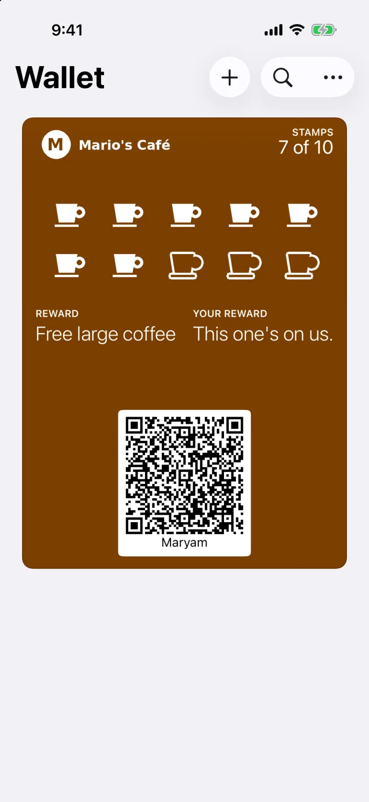 Apple Wallet on an iPhone showing a Mario's Café loyalty card with seven of ten coffee stamps, the reward Free large coffee, and the QR code staff scan at the counter.